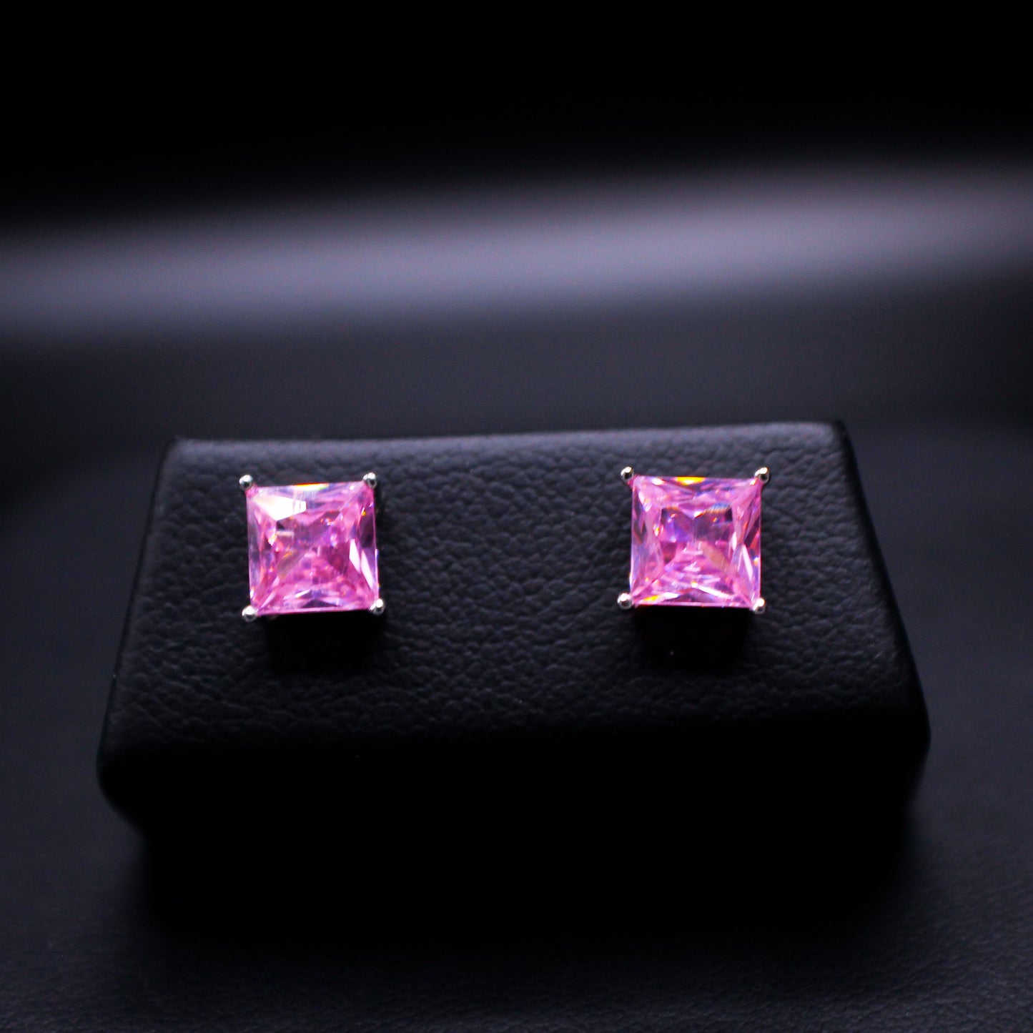 Pink synthetic sapphire princess cut earrings by Johnny's Ice & Co featuring sparkling gemstone and elegant jewelry design.