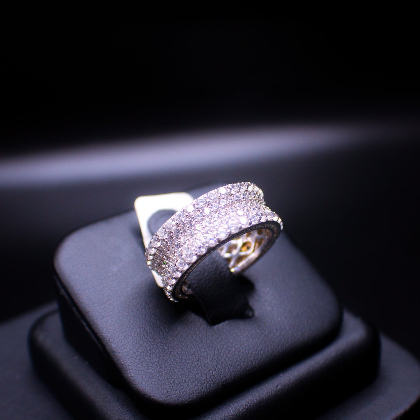 Sterling silver graduating eternity band ring by JohnnysIceAndCo, featuring a continuous row of varying-sized gemstone accents.
