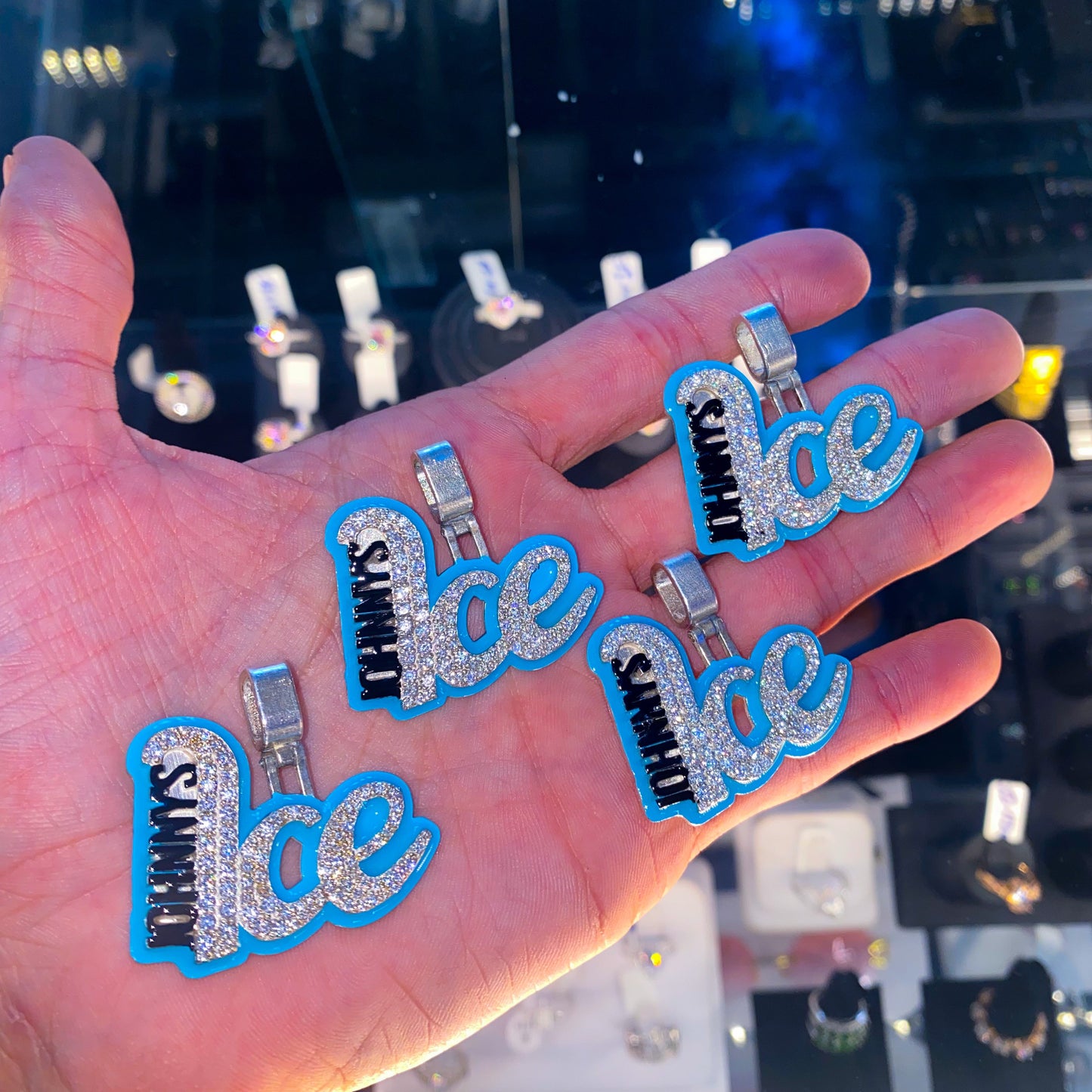Johnny ice and co logo pendants laying in hand