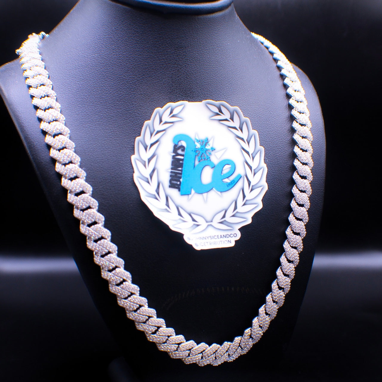 A silver Cuban link chain necklace displayed on a mannequin bust.