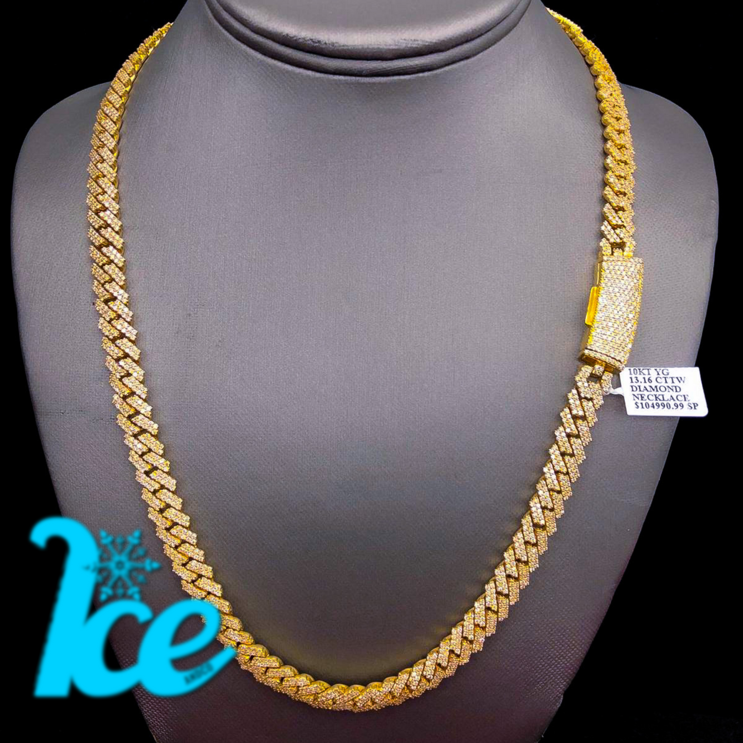 A gold Cuban chain necklace displayed on a mannequin with a diamond-encrusted clasp, predominantly yellow in color.