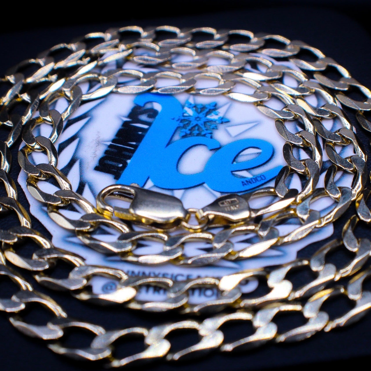 Gold chain with a blue logo on a dark background