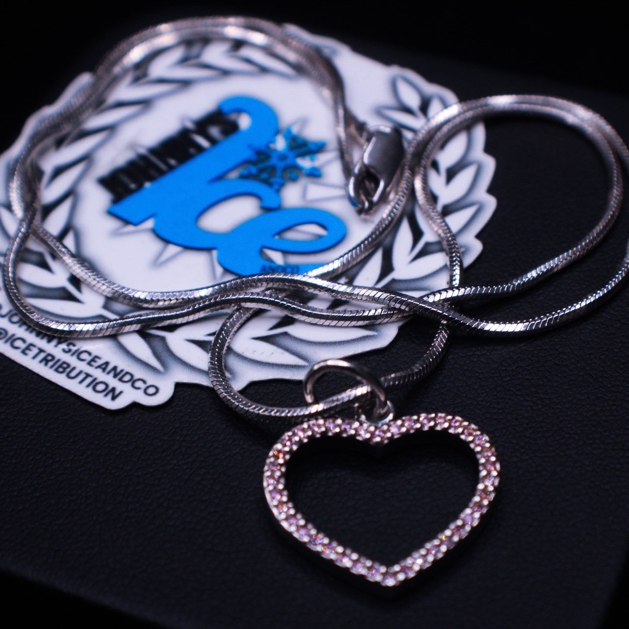 Silver heart-shaped Necklace with a Johnnysice background