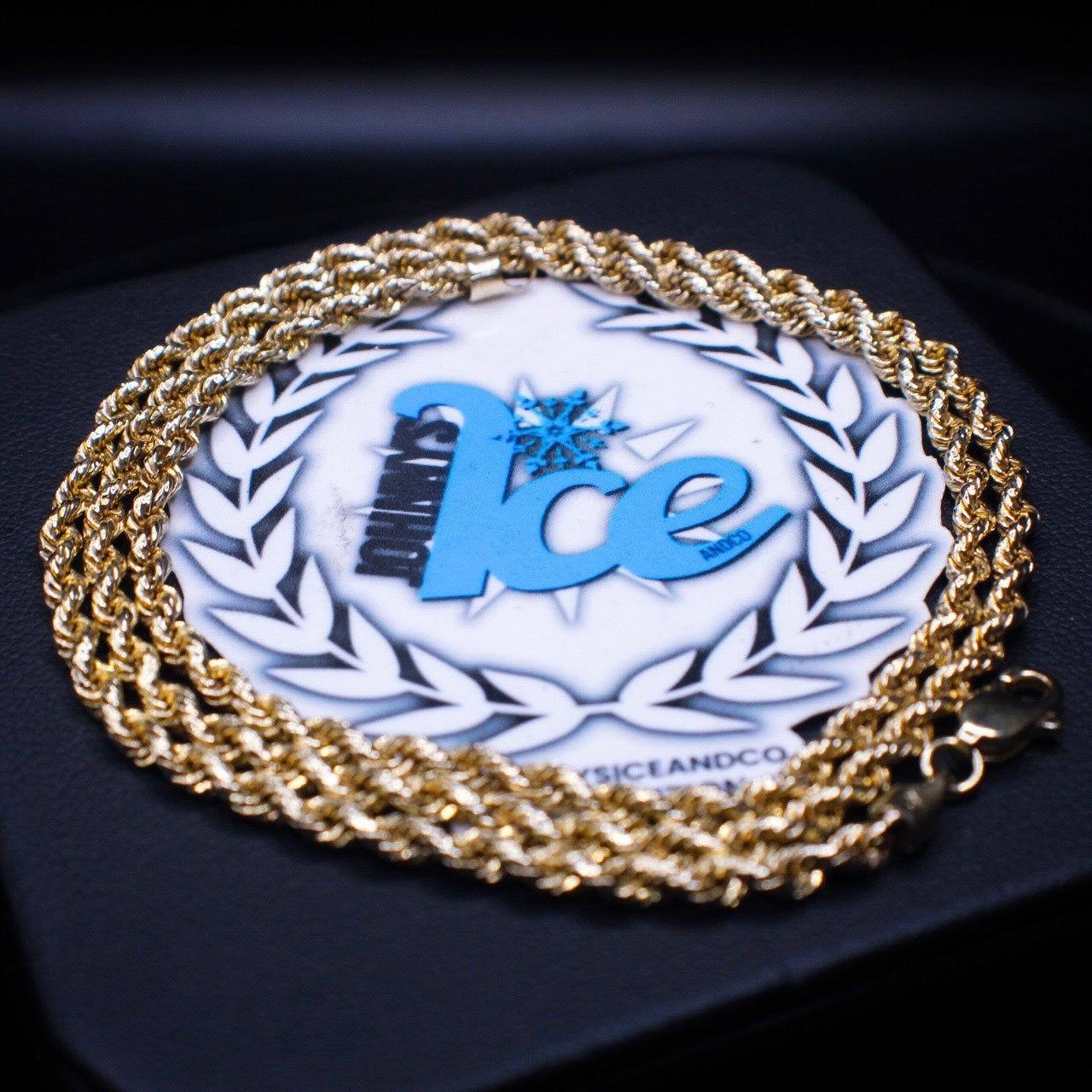 Gold chain with a blue 'Ice' logo on a dark background