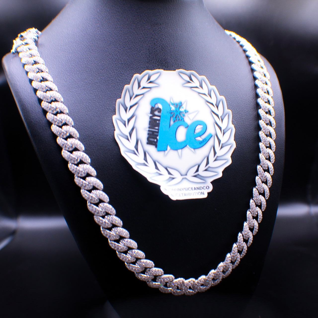 A silver Cuban link chain necklace displayed on a mannequin bust.